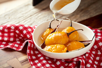 Homemade sweet tomate de árbol, a typical ecuadorian dessert served on a white plate with a rustic, traditional and homey background
