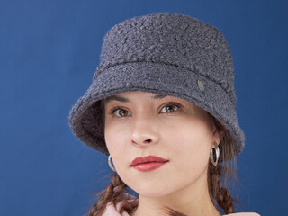 young lady in a panama hat on a blue background.