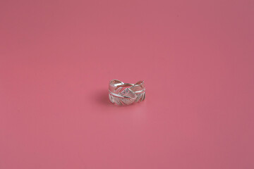 Jewelry on pink background close up, silver ring with precious stones
