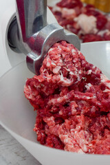 cooking minced meat in the kitchen with a meat grinder 