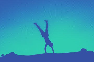 Silhouette of man doing acrobatics on a rock. Copy space. Half tone.