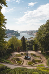 Views of the Arrábida Bridge over the Douro River in Porto, with the beautiful gardens of the Crystal Palace Park in the foreground.