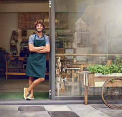 The secret to our amazing coffee lies behind these doors. Portrait of a successful young barista...