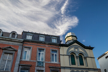 Fototapeta na wymiar Liege, Belgium, sunny summer afternoon street view. Impressive clouds above houses.
