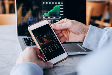 Stock market investor hands holding a phone investment app index growth chart, private banking, private investment. digital banking
