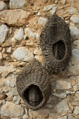 evocative image of ancient baskets hanging on a stone wall