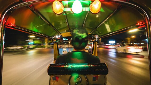 Motion time lapse view of tuk-tuk ride around Bangkok, Thailand, Southeast Asia nightlife and transportation concept.