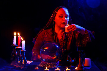 young woman fortune teller in the saloon with candles.