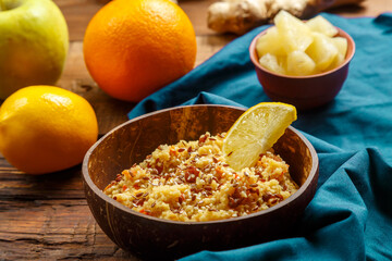 Couscous masfouf with dried fruits and nuts in a plate on a blue napkin next to fresh fruits.