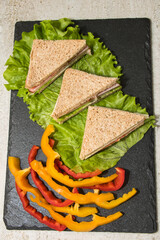 Sandwich with boiled pork and cheese on a lettuce leaf
