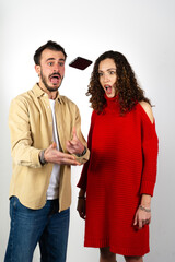 Smartphone slipping from a boy's hands near her girlfriend with upset expression