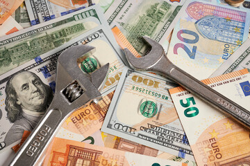 Wrenches - photo on money bank notes. Wrench and spanner are laying on money bank notes. Dollar and...