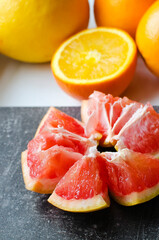 Different citrus fruits lie on the windowsill. Close-up, selective focus. Oranges and peeled grapefruit, vertical photo. The concept of healthy natural food containing vitamins.