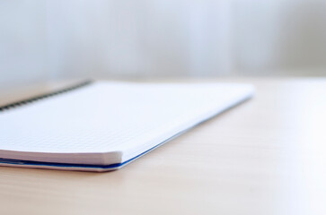 Blurred background with blank notepad on the table. Background for design, advertising, web. Place for text, copyspace.