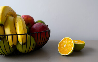 healthy fruits in a basket. Banana, orange, apple, mango, limon.