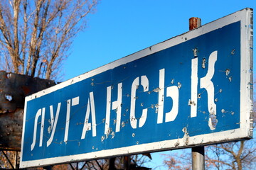 Obraz premium Ukraine Russia war Road sign in Ukrainian - Lugansk, pierced by bullets, Ukrainian war in Donbass destruction, Ukraine border, ATO OOS zone