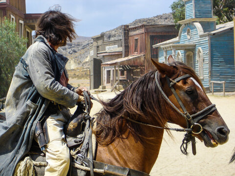 Cowboy o pistolero encima del caballo buscando su enemigo en el lejano oeste americano.