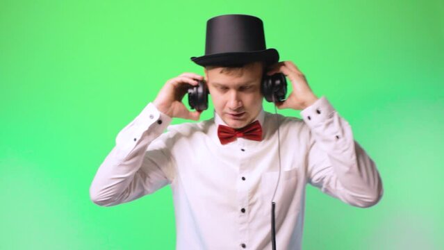 young man artist dj in a hat and bowtie glasses happy performer chromakey music