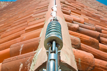 Horizontal lifeline fall protection system with inox stainless cable on terracotta roof used to prevent the danger of falling - obrazy, fototapety, plakaty