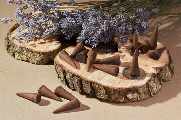 Incense cones for aromatherapy with lavender flowers on a brown background. Burning incense cone 