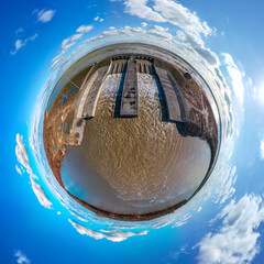 The spillway of the Shapshug reservoir into the Kuban river - aerial little planet view panorama on a winter sunny day - obrazy, fototapety, plakaty
