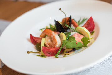 Seafood Poached in Broth wit Vegetables and Fresh Herbs