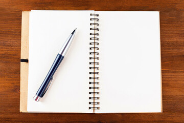Open notepad with blank pages and a pen on a white background.Mock up.	
