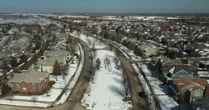 Aerial view of a neighborhood with homes and townhomes in winter.