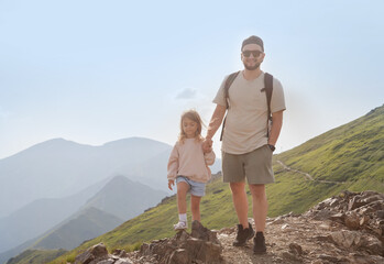 Father with child walking on the mountain and enjoying beautiful view. Family hiking.