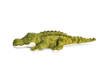 Doll of a green combed crocodile on a white background.