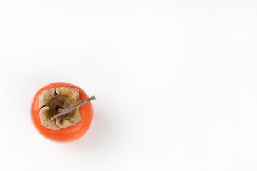 Persimmon lies on a white background. Top view, copy space, close-up, horizontal orientation.