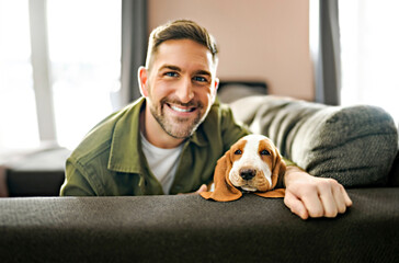 Man Playing With basset Pet Dog At Home sofa.