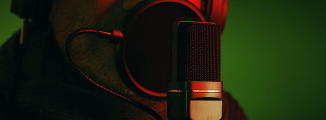 Close up look of a studio microphone and a man, green background