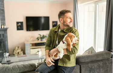 Man Playing With basset Pet Dog At Home living room