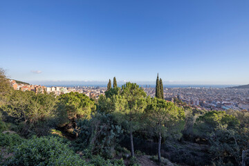 Fototapeta na wymiar View of the city of Barcelona from the mountain on a sunny day. Urban landscape. Blue sky over the city.