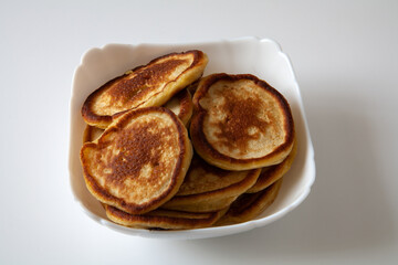 On a white plate are pancakes. On a white background.