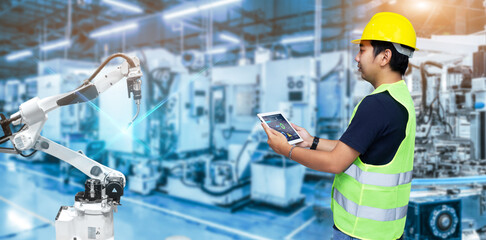 Smart industry control concept.Engineer Hands holding tablet on blurred robot arm automation...