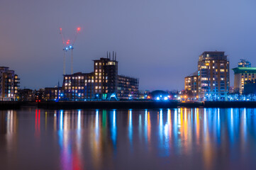 Fototapeta na wymiar Panoramic view of the Rotherhithe residential buildings reflected in the Thames River at night, in London
