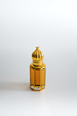 Arabian oud perfume in mini gold bottle. Isolated on white background. Copy space. 