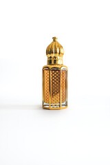Arabian oud perfume in mini gold bottle. Isolated on white background. Copy space. 