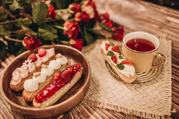 Fototapeta premium plate with cakes and a cup of tea on a wooden table