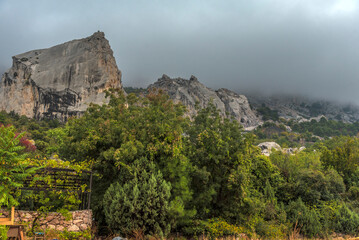 Stony slopes of mountain in dense fog.