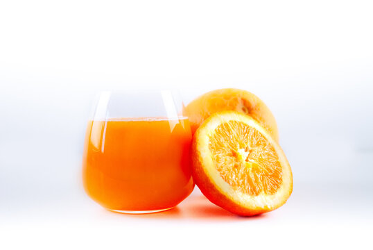 Bicchiere di spremuta di arance con due arance