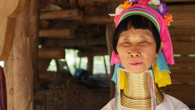 Karen Long Neck woman wearing traditional clothing and brass neck rings at hill tribe village near Chiang Rai, Thailand.	
