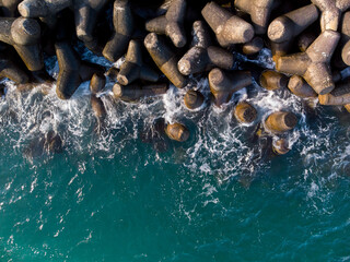 Aerial drone view of a breakwater. breakwater in the sea, a collection of concrete breakers - Powered by Adobe