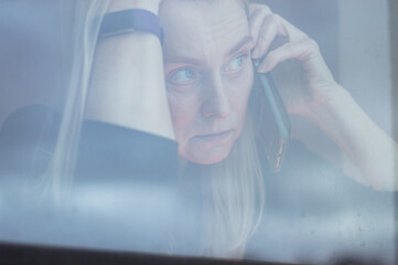 Woman behind window speaking on phone