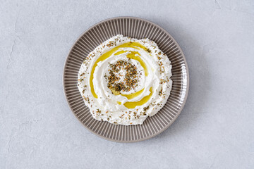 Labneh yogurt, cream  cheese with olive oil and zaatar . Traditional middle eastern arabic breakfast dip.Top view - obrazy, fototapety, plakaty