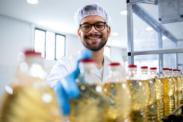 Industrial production of refined vegetable oil and factory worker controlling production on...