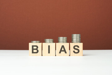 bias text on wooden blocks with coins on brown background