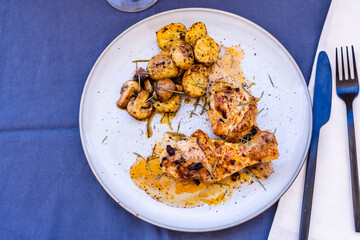 Top view of some delicious baked chicken legs with rustic potatoes and some delicious boletus sauteed in EVOO and Spanish paprika.
